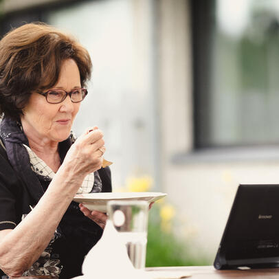 A senior resident having a meal by a remote care device.