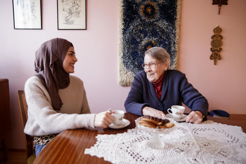 En yngre och en äldre kvinna dricker kaffe tillsammans vid bordet.