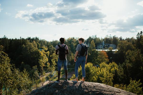 Men standing on top of a rock in a green area